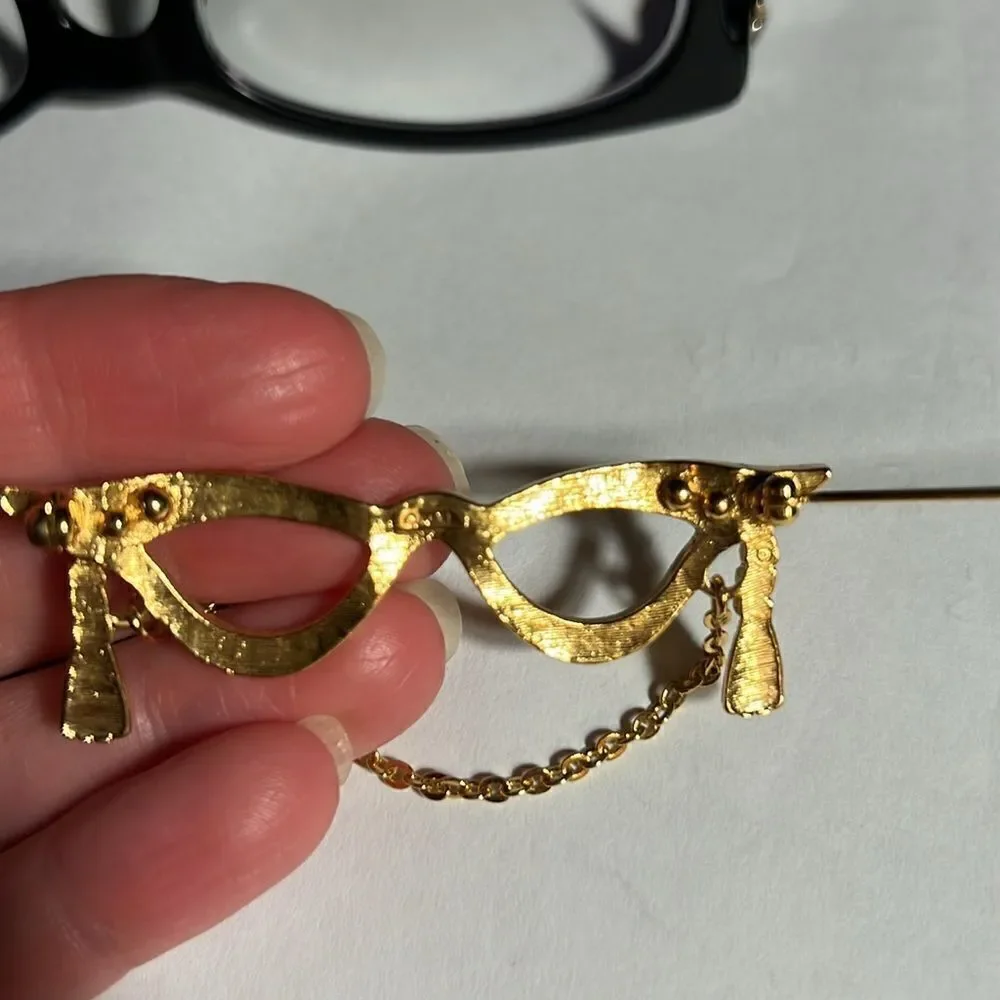 Avon golden eyeglass holder brooch with gold tassel.